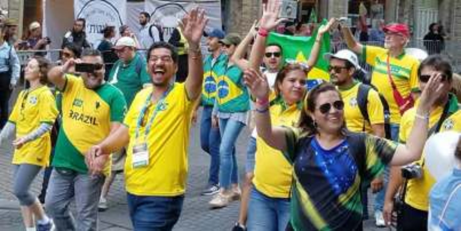 A group in yellow and green clothing waving during a gathering in Israel